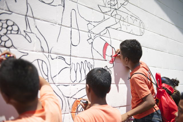 Colouring a mural at Ejit Elementary School
